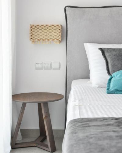 a bedroom with a bed and a table next to a bed at Angelos Boutique Suites in Patitiri