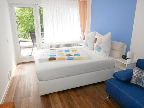 a bedroom with a large white bed and a window at Apartment Möwe in Meersburg