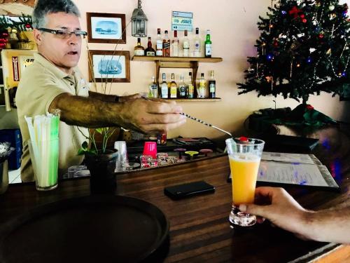 a man standing at a bar with a drink at Plantation Beach Villas in Black Rock