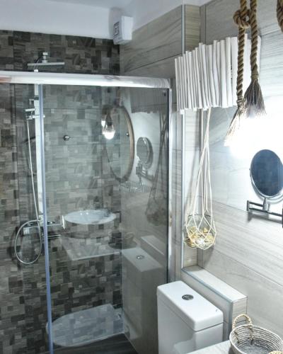a bathroom with a glass shower and a toilet at Angelos Boutique Suites in Patitiri