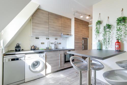 une cuisine avec lave-linge, sèche-linge et une table dans l'établissement Duplex apartment with sea view and roof terrace, à Trouville-sur-Mer