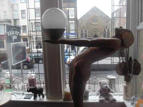 a statue of a woman sitting in a window at Bradleys Hotel in Blackpool