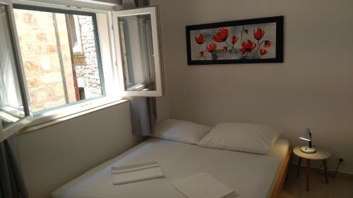 a small bed in a room with a window at privat room with privat bathroom David in Hvar