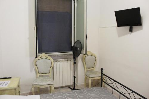 - deux chaises dans une chambre dotée d'une fenêtre et d'une télévision dans l'établissement La Vela, à Furore