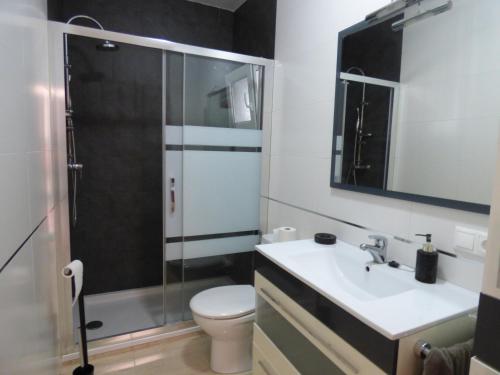 a bathroom with a toilet and a sink and a shower at Reus Mediterrani in Cambrils