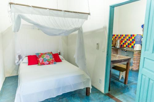 a bedroom with a bed with a canopy at Casa Aconchegante em Caraíva - Casas Do San in Caraíva