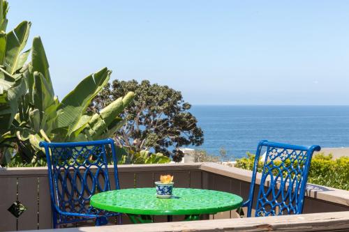a green table and two chairs on a balcony with the ocean at Casa Laguna Hotel & Spa in Laguna Beach