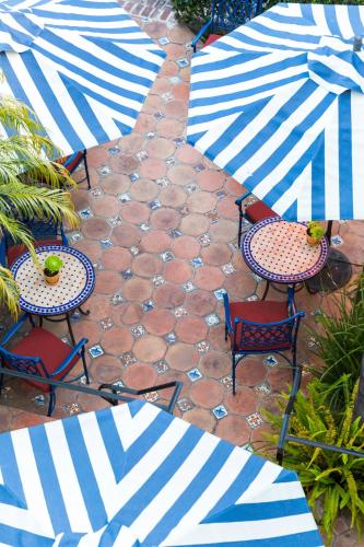 a patio with tables and chairs with blue and white umbrellas at Casa Laguna Hotel & Spa in Laguna Beach