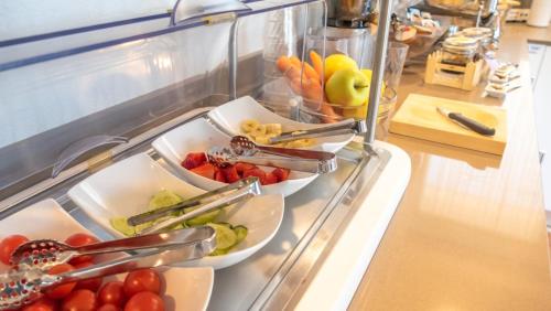 a buffet with two trays of fruits and vegetables at Hotel Casa Marinella in Malcesine