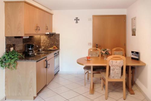 a kitchen with a wooden table and a table and chairs at Appartement Flora in Saas-Almagell