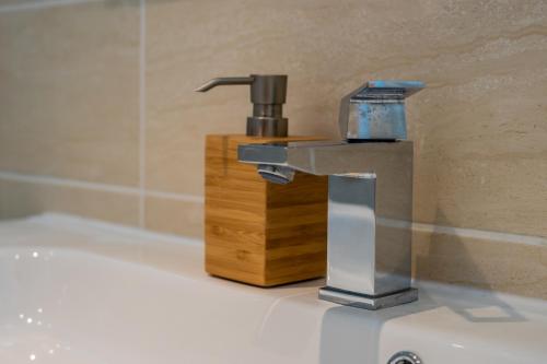 - un lavabo avec robinet à côté d'un bloc en bois dans l'établissement L'Ascot Appartement, plages à 300m, vue hippodrome, à Cagnes-sur-Mer