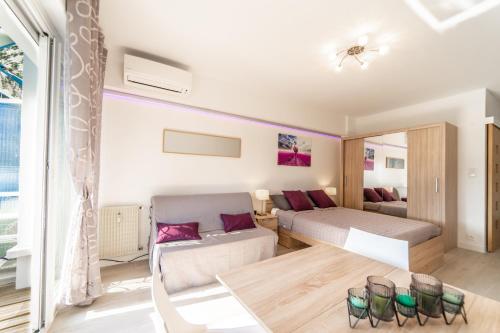 une chambre avec un lit, un canapé et une table dans l'établissement L'Ascot Appartement, plages à 300m, vue hippodrome, à Cagnes-sur-Mer