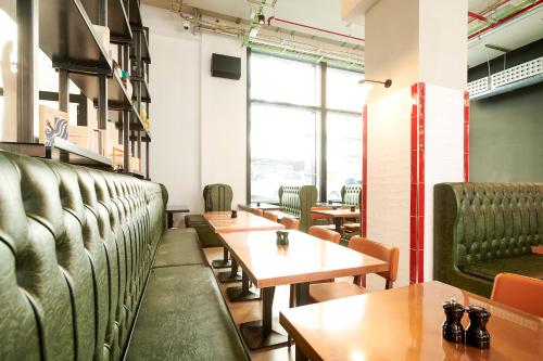 a dining room with green booths and tables at Generator Madrid in Madrid