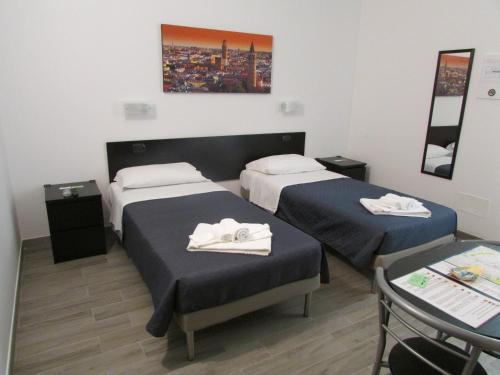 una habitación de hotel con dos camas y una mesa en Affittacamere Verona in, en Verona
