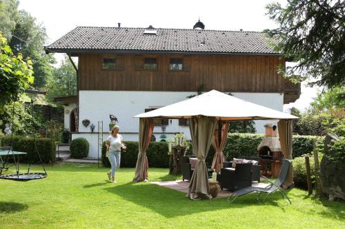 a woman walking in a yard with an umbrella at Haus Südblick in Zell am See