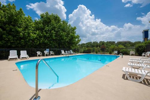 a large swimming pool with lounge chairs at Brookwood Inn Branson in Branson