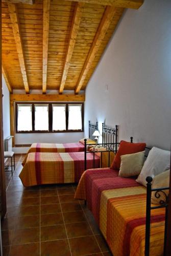 a bedroom with two beds and a wooden ceiling at Casa Rural GAUBEKA in Bakio