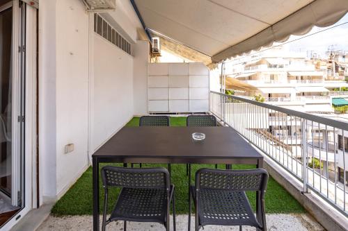 een balkon met een tafel en 2 stoelen bij Artemis - Athens Deluxe City Center Apartment in Athene