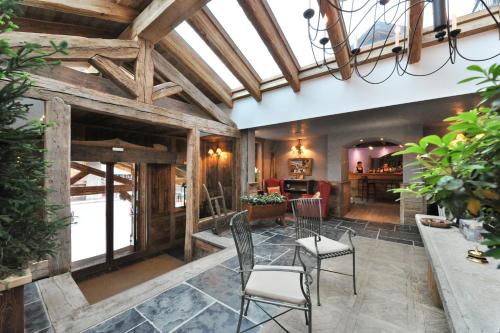 an open living room with wooden ceilings and chairs at Hotel Bucaneve in Breuil-Cervinia