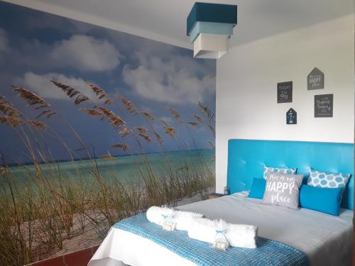 ein Schlafzimmer mit einem Wandbild des Strandes in der Unterkunft Apartamento em D'el Rey-Obidos Beach & Surf in Amoreira