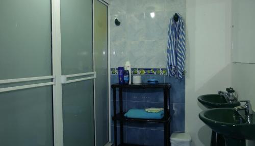 a bathroom with a toilet, sink, and shower stall at Big V Raizal Home in San Andrés