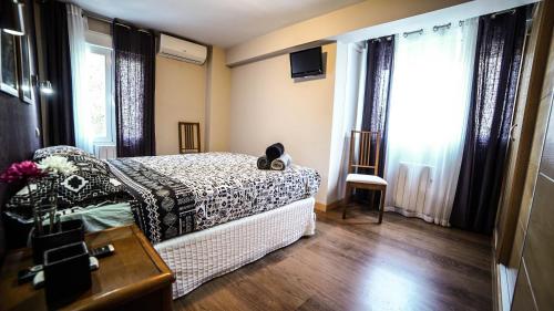 - une chambre avec un lit, une commode et des fenêtres dans l'établissement Apartments Madrid Eliptica, à Madrid