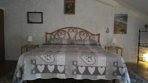 a bedroom with a bed with a black and white blanket at Casa Vacanze del Borgo in Sassetta
