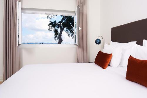 a bedroom with two beds and a window at Convento do Seixo Boutique Hotel & Spa in Fundão