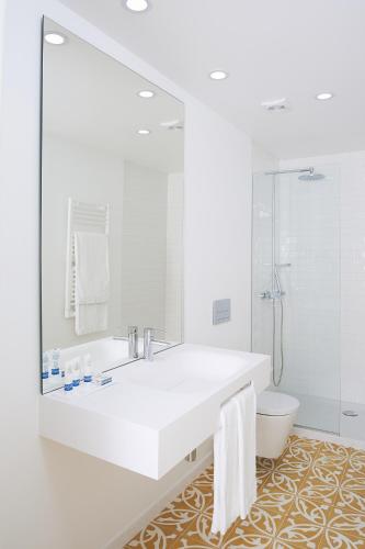 a white bathroom with a sink and a toilet at Convento do Seixo Boutique Hotel & Spa in Fundão