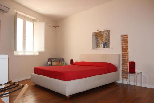 sypialnia z łóżkiem z czerwonym kocem w obiekcie Dimora di Charme Cassaro 168 w mieście Marsala