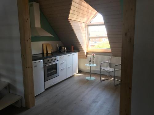 eine Küche mit weißen Schränken und einem Fenster in der Unterkunft Appartement Ginstertraum in Lüneburg