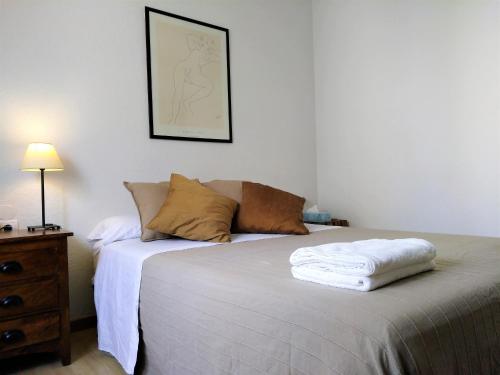 een slaapkamer met een bed, een dressoir en een foto bij Suitur Atico Sitges Centro in Sitges