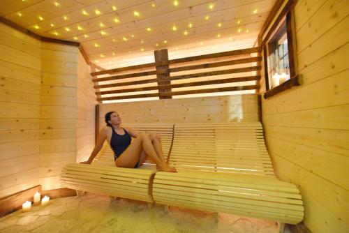 a woman is sitting in a sauna at Hotel Bucaneve in Breuil-Cervinia