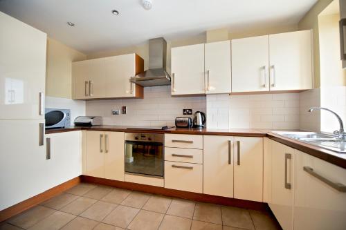 a kitchen with a stove top oven and a sink at Staycity Aparthotels Saint Augustine Street in Dublin