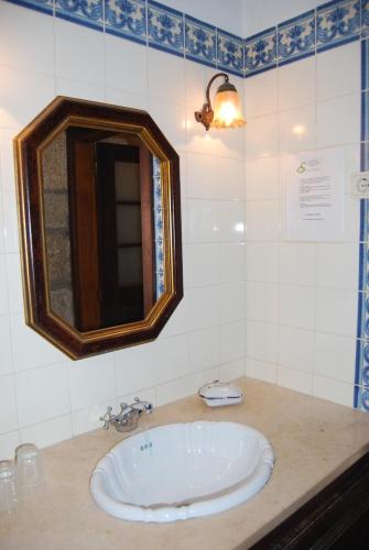 a bathroom with a sink and a mirror on a counter at Agro-Turismo Quinta do Pendao in Santa Cruz da Trapa