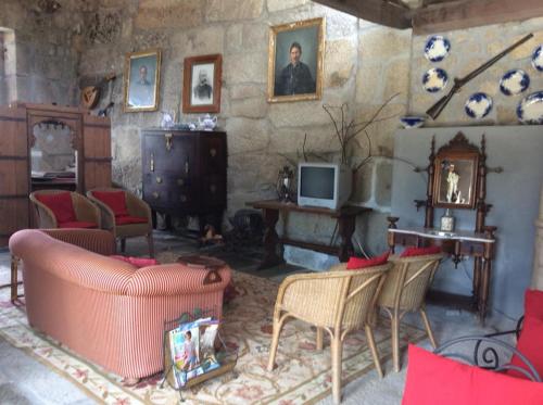a living room with a couch and a table and a television at Agro-Turismo Quinta do Pendao in Santa Cruz da Trapa
