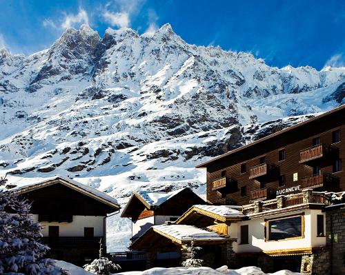 a snow covered mountain in front of a building at Hotel Bucaneve in Breuil-Cervinia