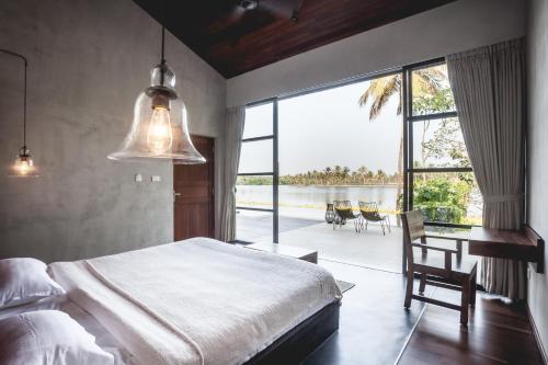 a bedroom with a bed and a desk and a large window at 976 Panangad in Cochin