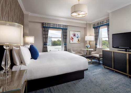 a hotel room with a large bed and a flat screen tv at Fairmont Empress Hotel in Victoria