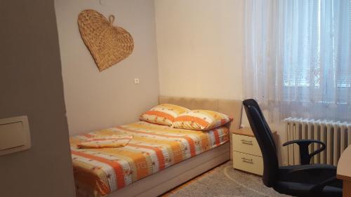 a bedroom with a bed and a chair and a window at Apartment Zenica in Zenica
