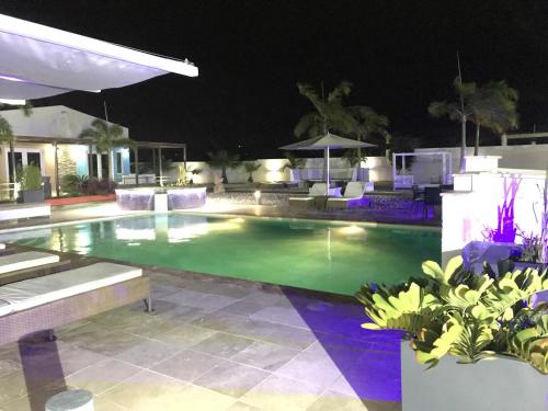 a swimming pool at night with lights at Malika Apartments in Westpunt