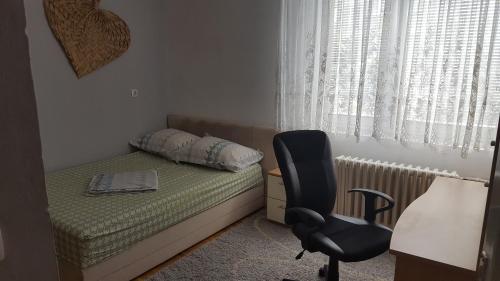 a bedroom with a bed and a chair and a desk at Apartment Zenica in Zenica