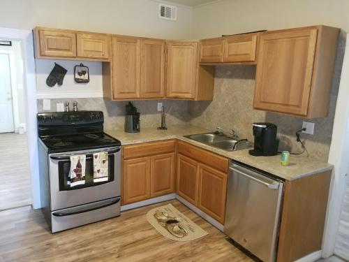 夏安的住宿－500/502 W 23rd St，厨房配有木制橱柜、炉灶和水槽。