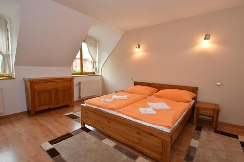a bedroom with a large bed with orange pillows at Central Apartmany in Vysoke Tatry - Stary Smokovec