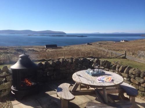 HallinにあるDunhallin Ardのピクニックテーブル、海の景色を望む暖炉