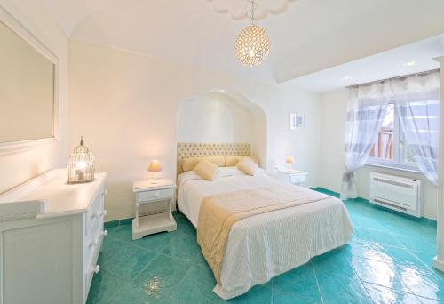 a white bedroom with a bed and two night stands at Villa dei Lecci - 7 Luxury villas with private pool or jacuzzi in Ischia