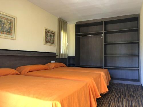 ミアミ・プラトーヤにあるRentalmar Margaritaのベッドルームにオレンジのシーツが備わるベッド2台