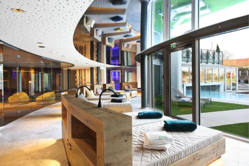 a room with a bed in a building with windows at Das Stemp Wellnessresort 4 Sterne Superior in Büchlberg