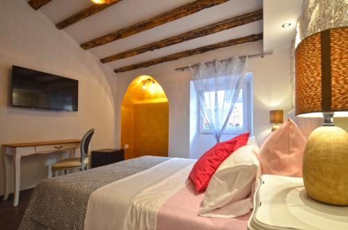 Schlafzimmer mit einem Bett mit roten Kissen und einem Schreibtisch in der Unterkunft Noanna Apartment in Rovinj