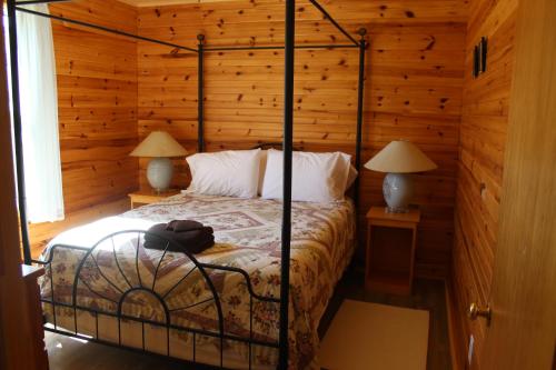 a bedroom with a bed with a wooden wall at Chalets Grand Pre Cottages in North Rustico